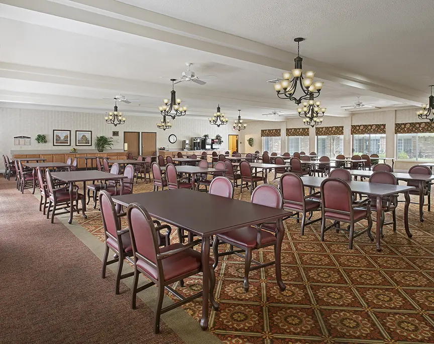 Large carpeted dining hall at American House Livonia, a senior living community in Livonia, Michigan