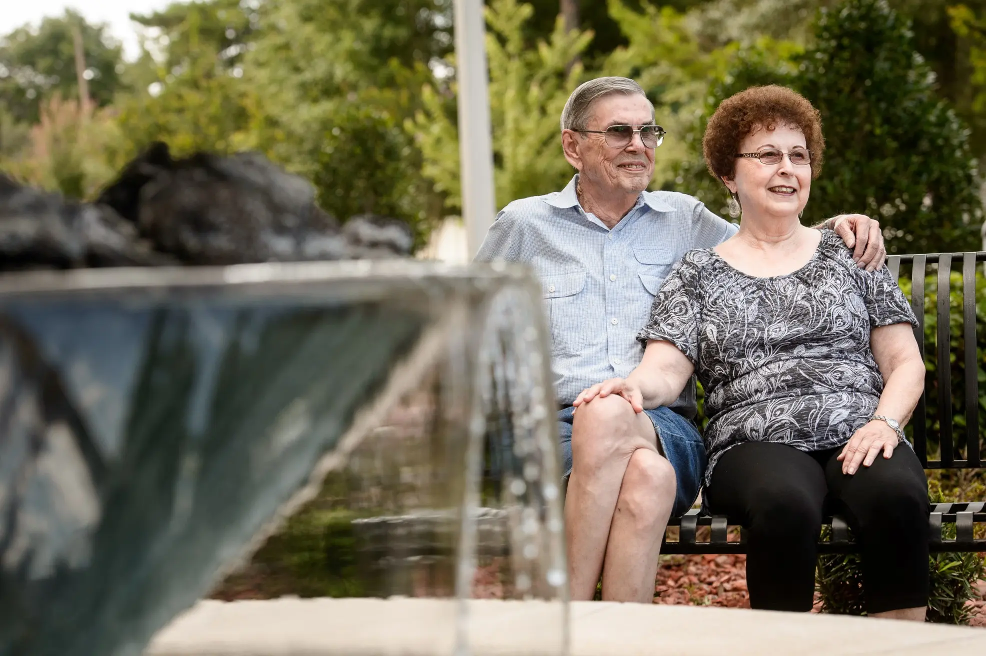 Seniors sitting by a fountain outside of a senior living community in Niceville, FL