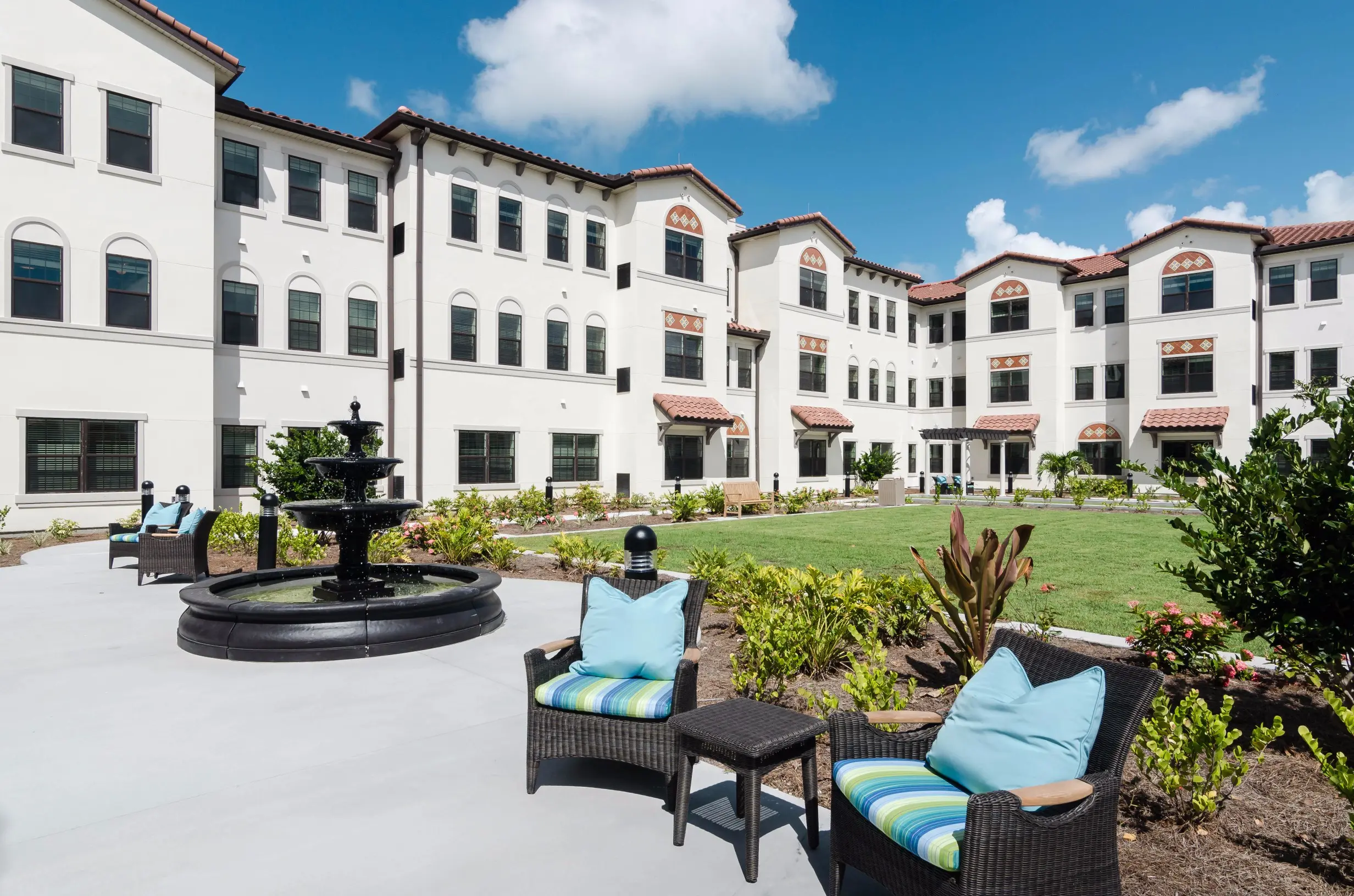 Exterior shot / fountain of American House Coconut Point, a senior living community in Estero, FL