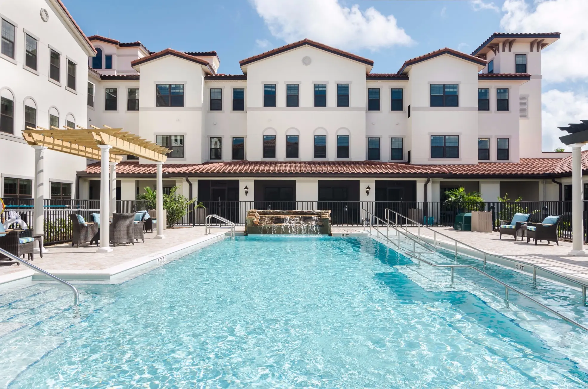 Exterior shot / pool of American House Coconut Point, a senior living community in Estero, FL