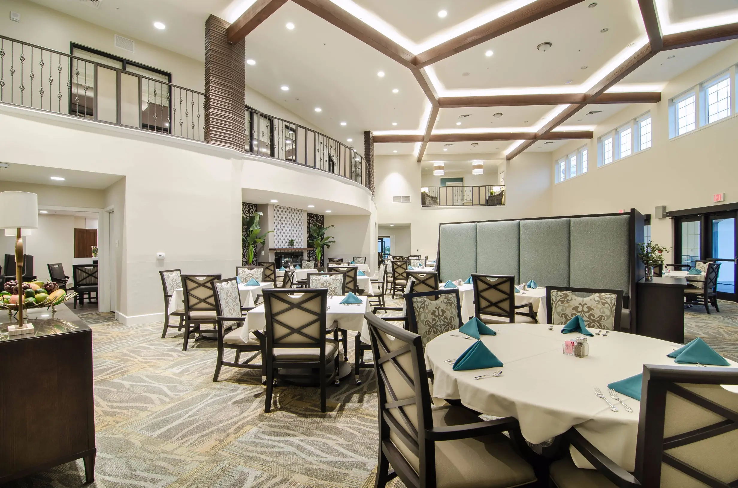 Large carpeted dining area at American House Coconut Point, a senior living community in Estero, FL