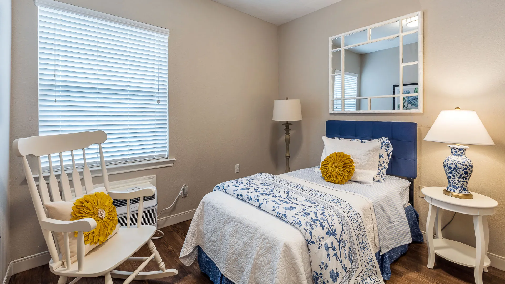 Bedroom with lamps and rocking chair at American House Bartlett