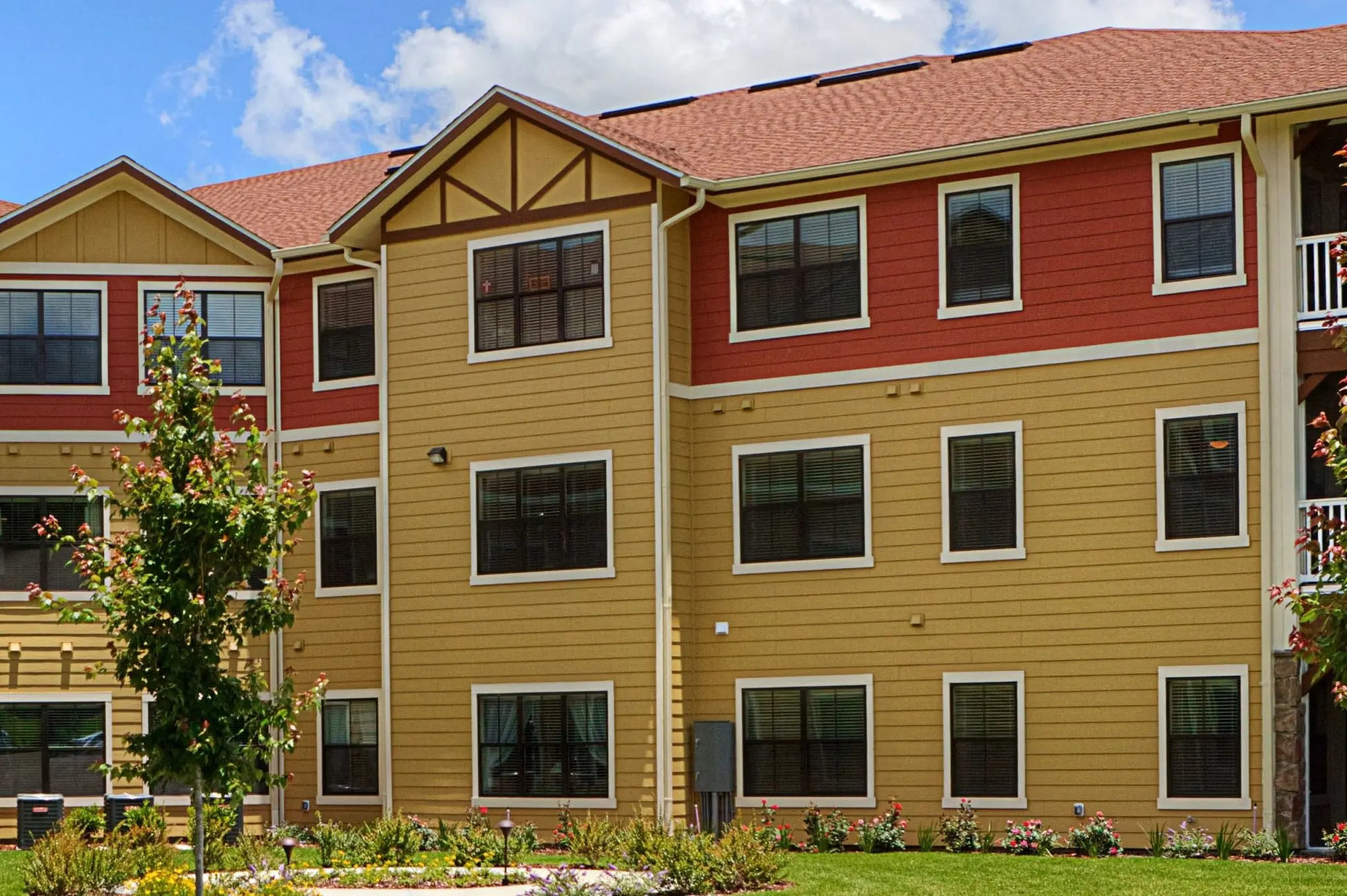 Rear exterior of yellow and orange senior living apartment building in the Villages in Wildwood, FL