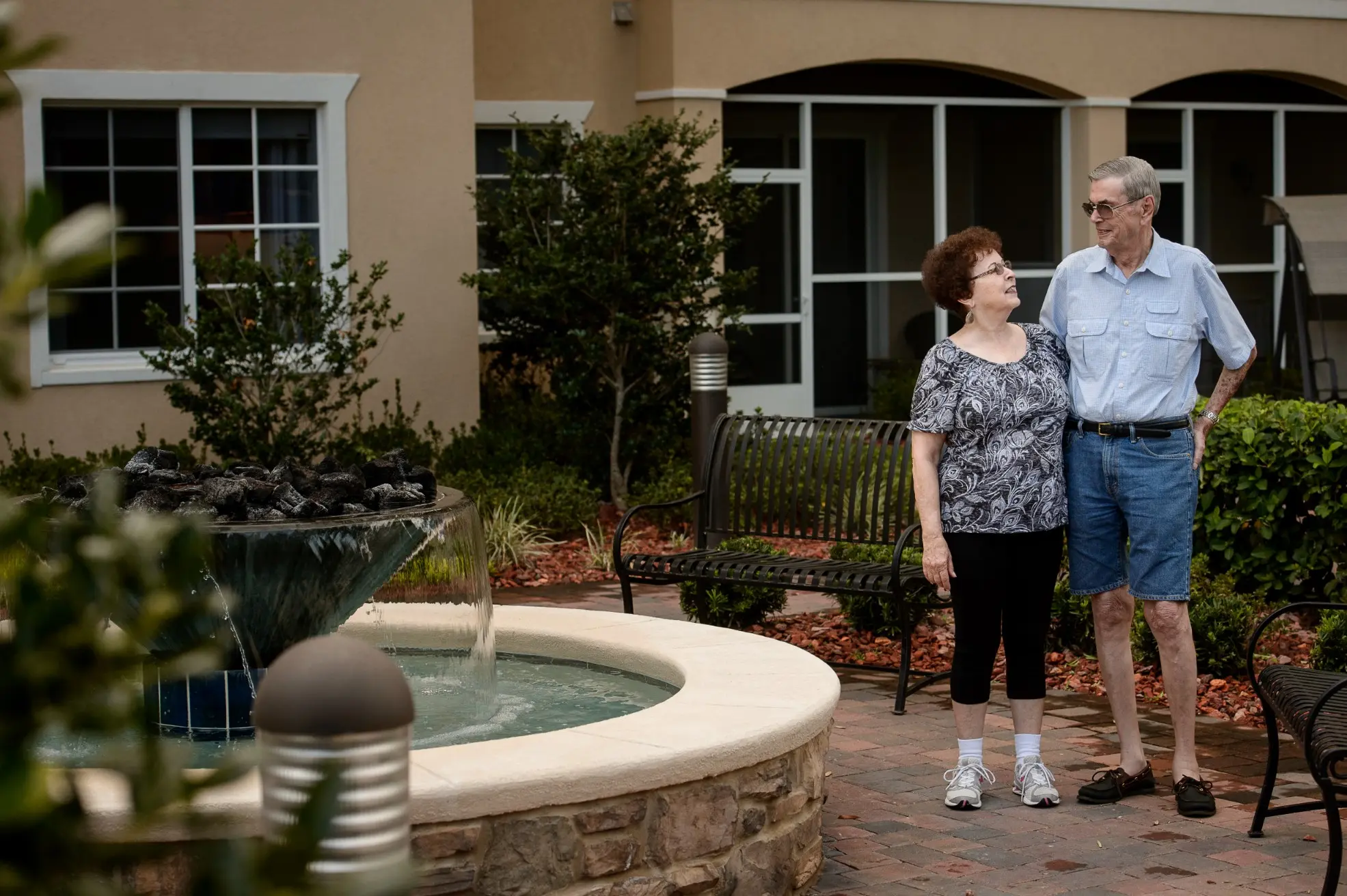 Seniors walking by a fountain outside of a senior living community in Niceville, FL