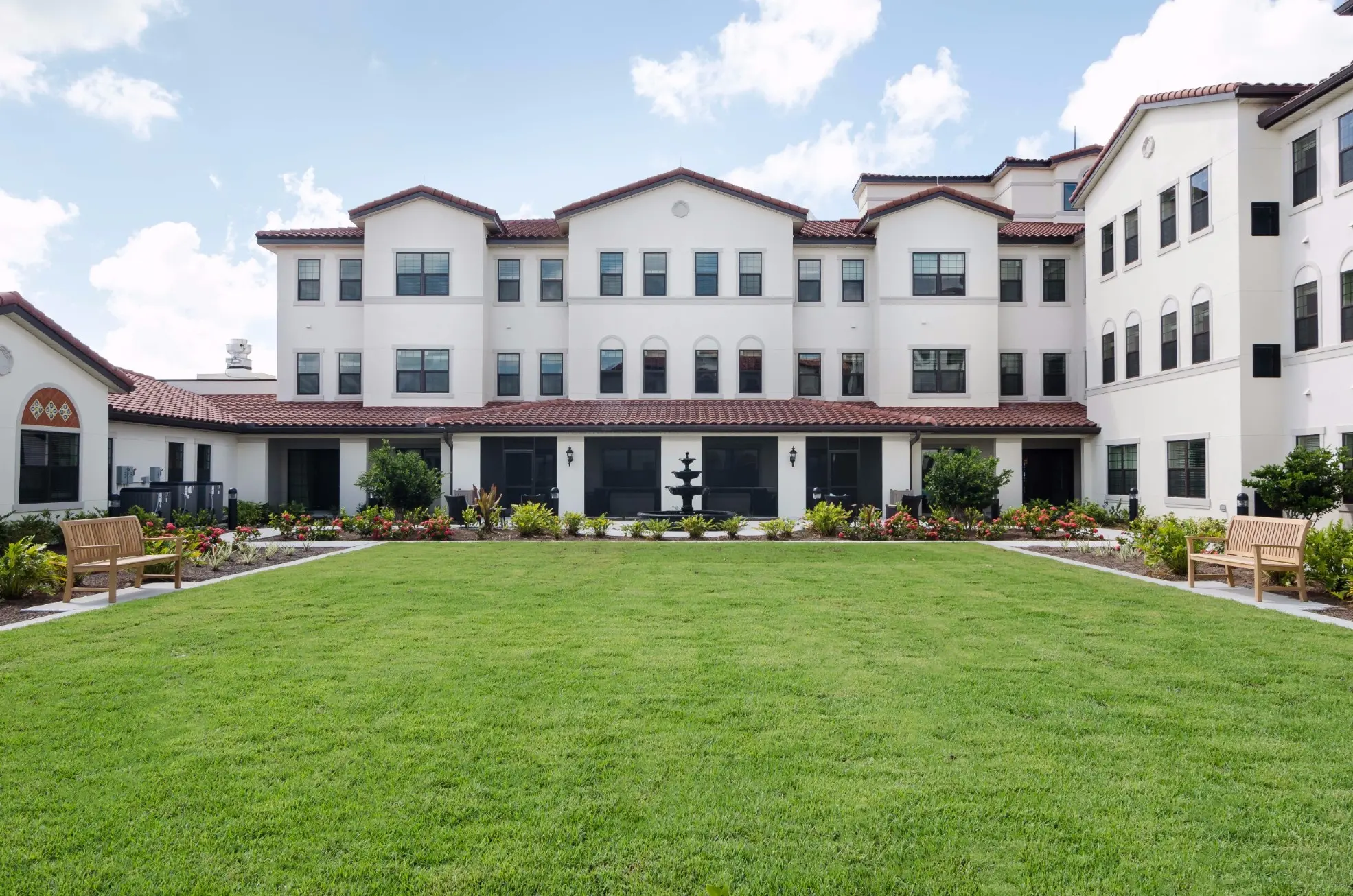 Exterior shot / courtyard of American House Coconut Point, a retirement community in Estero, FL