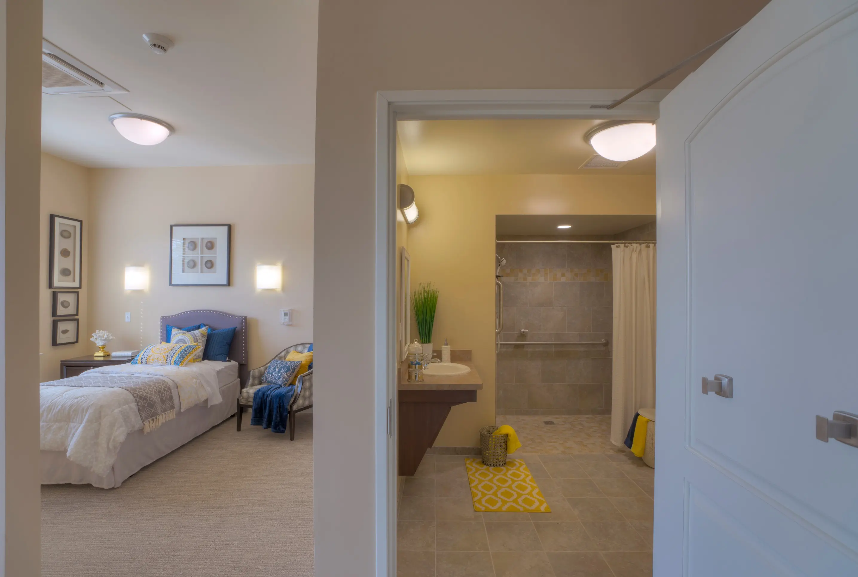 Bedroom and bathroom of a senior apartment at American House Freedom Place Roseville, a memory care community in Roseville, Michigan