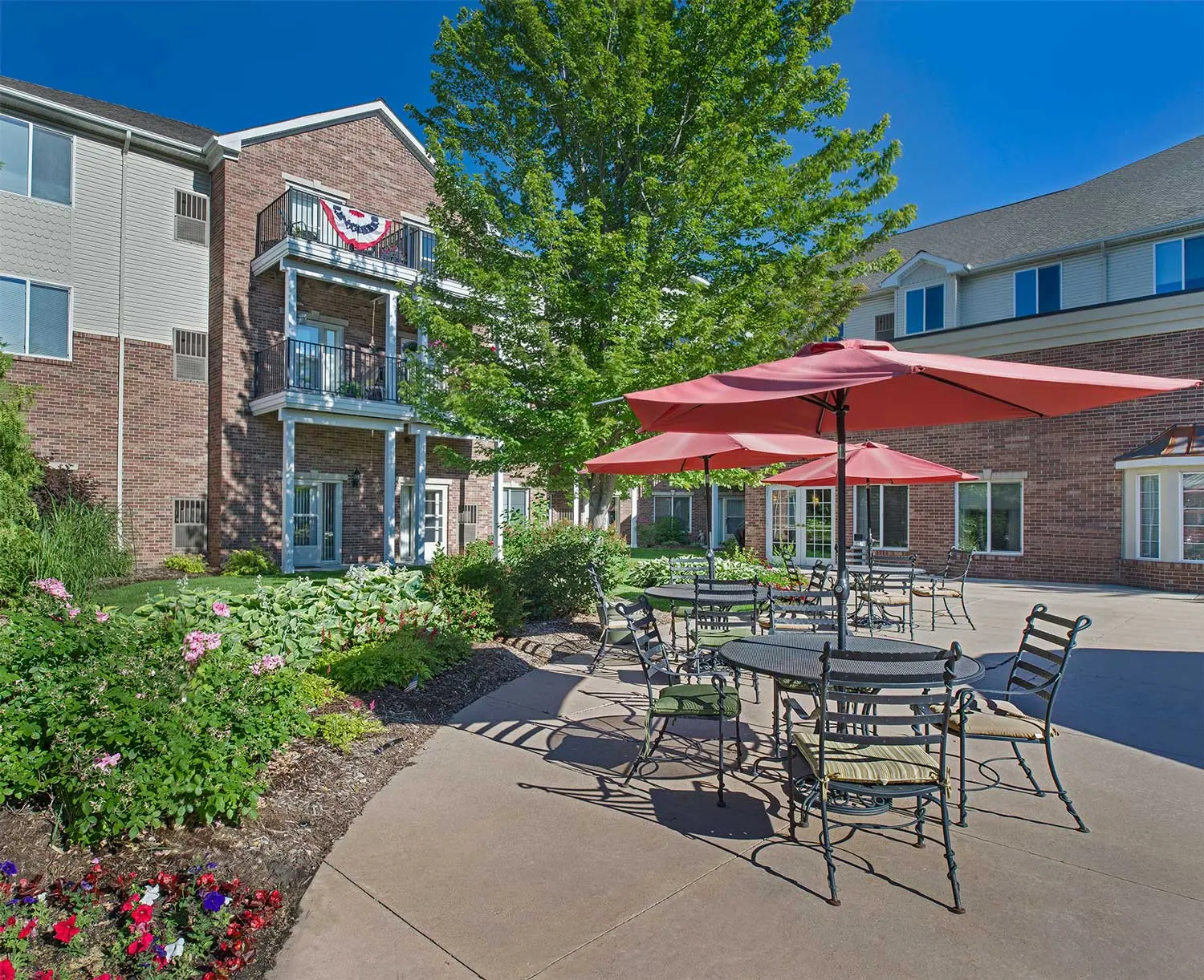 Patio furniture and garden on a clear sunny day at American House senior housing in North Sterling Heights, MI