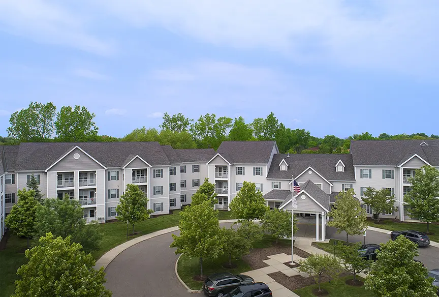 High angle view of retirement home entrance with trees and green grass in troy, MI