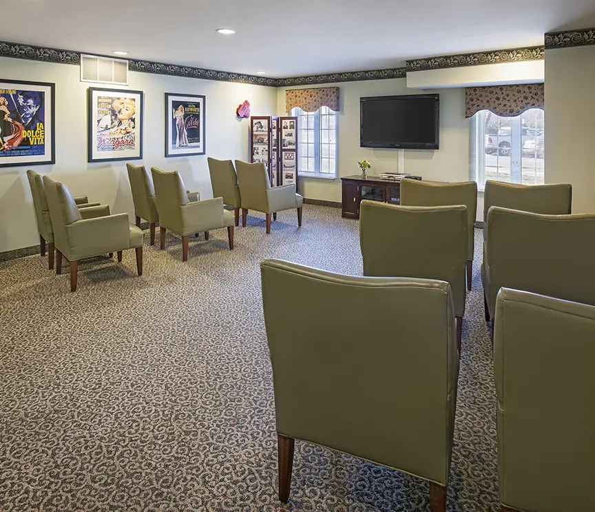 A theater with large chairs and large TV in a senior care home in Troy, MI