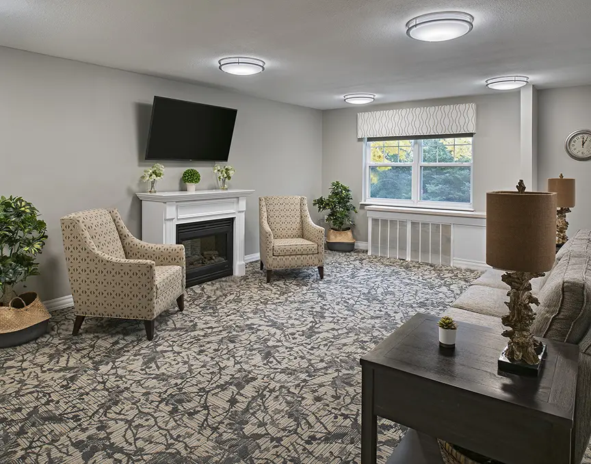 Living room with fireplace and flat screen tv at convalescent home in Rochester Hills, MI