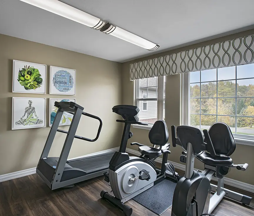 Three exercise machines in front of window at American House assisted living facility in Rochester Hills, MI