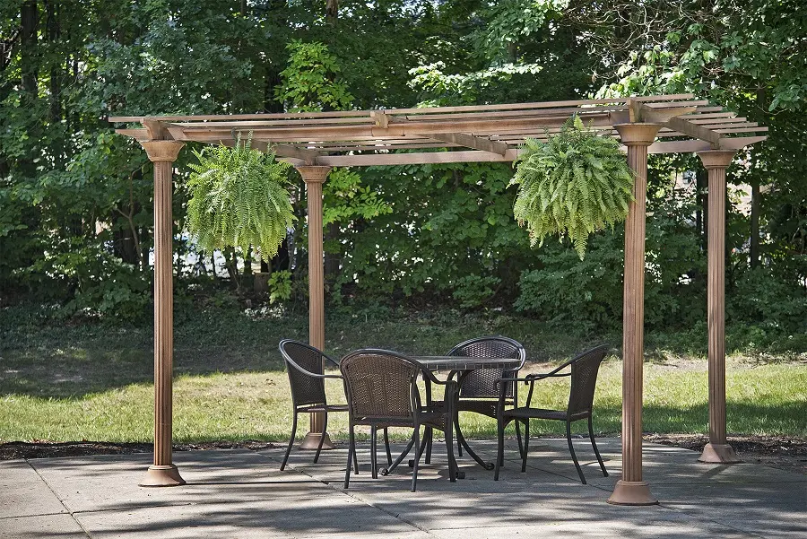 Pergola with ferns and patio furniture at an assisted living community in central Westland, MI
