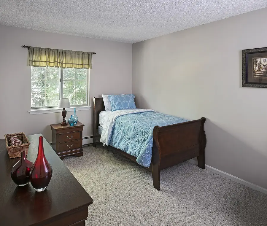 Bedroom with blue bedcovers in a retirement home in Westland, MI.