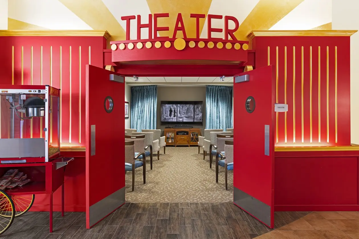 Theater entrance with yellow and red finishes and popcorn machine at a senior housing apartment in Wyoming, MI