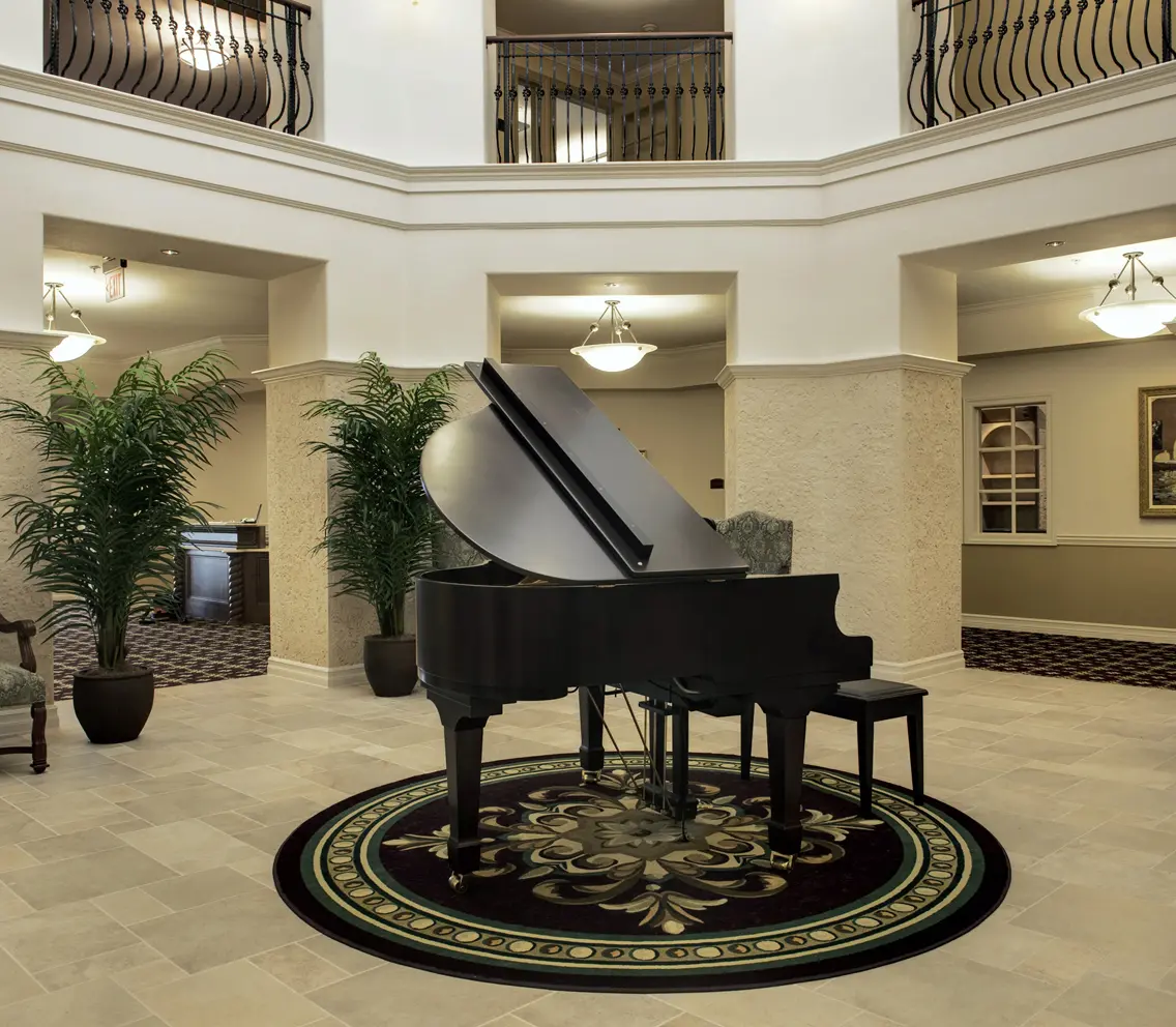 A grand piano in a three-story atrium at an assisted living facility in Zephyrhills, FL