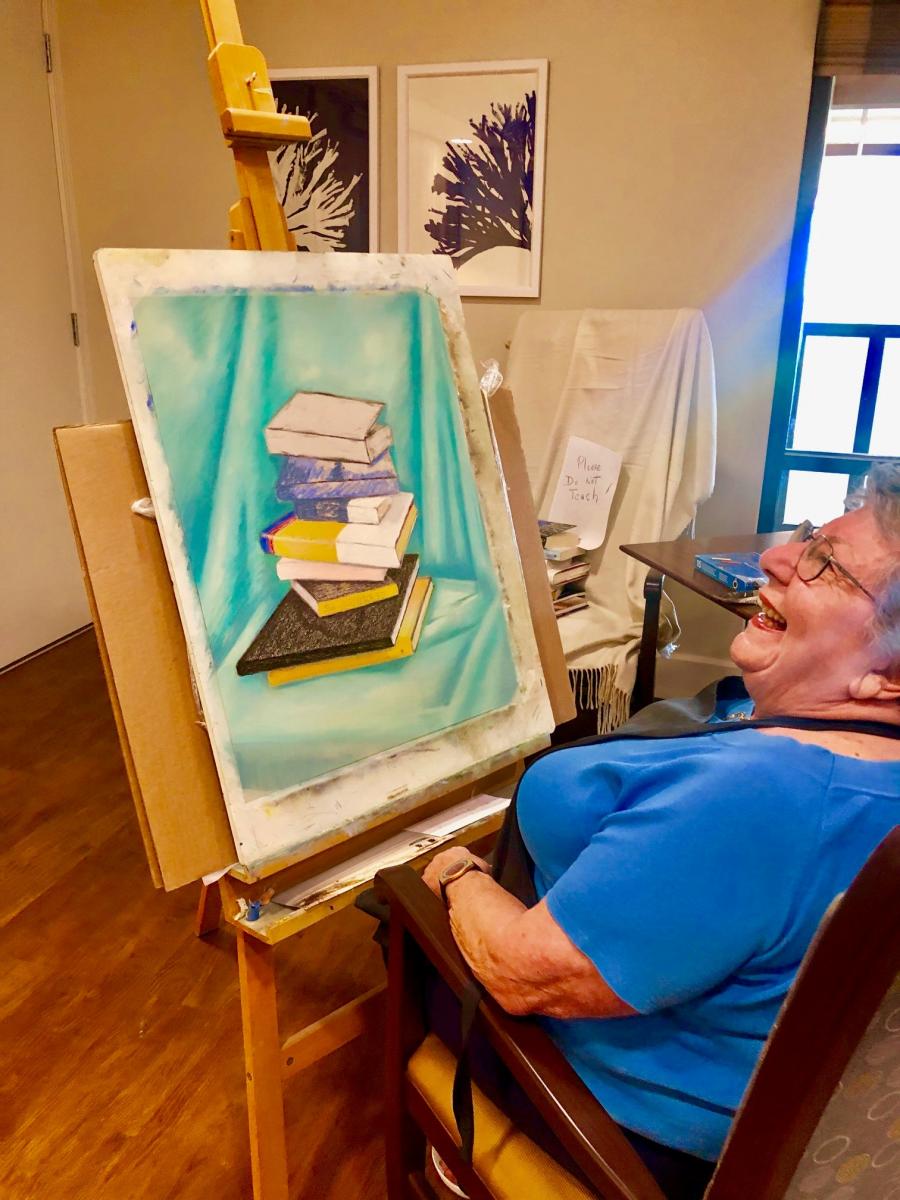 Older woman laughing at painting